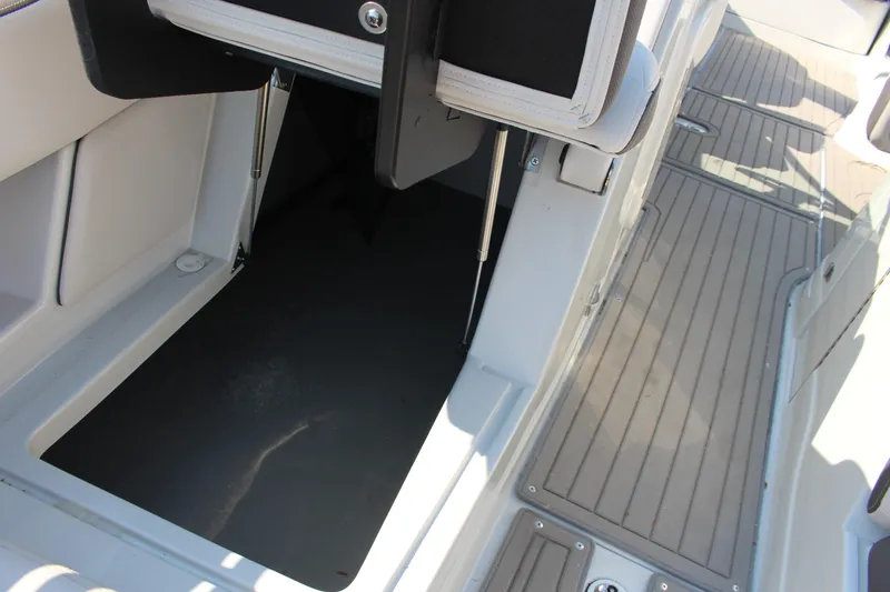 Slide: The Image of 2023 Crownline E285 boat storage compartment with open hatch and deck view. - 51