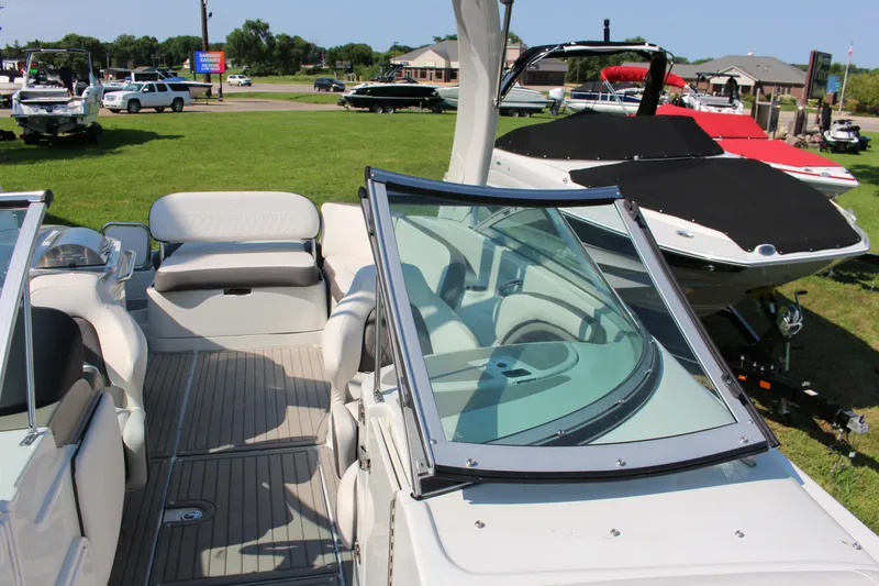 Slide: The Image of 2023 Crownline E285 boat interior with seating and windshield, displayed outdoors. - 55