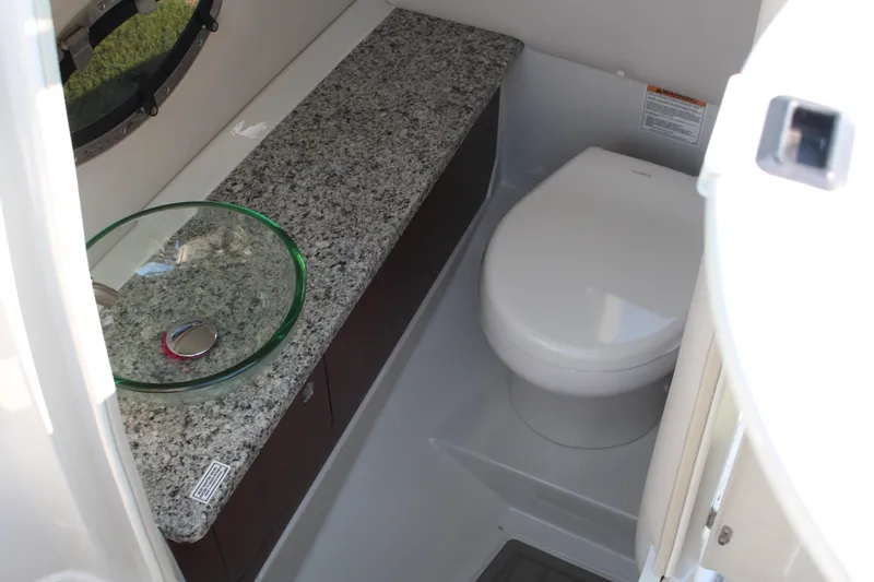 Slide: The Image of 2023 Crownline E285 boat bathroom with granite countertop and modern fixtures. - 58