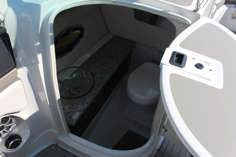 Slide: The Image of 2023 Crownline E285 boat interior with compact bathroom and modern amenities. - 59