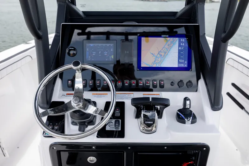 Slide: The Image of 2024 Yamaha Boats 255 FSH Sport H dashboard with steering wheel and navigation display. - 14