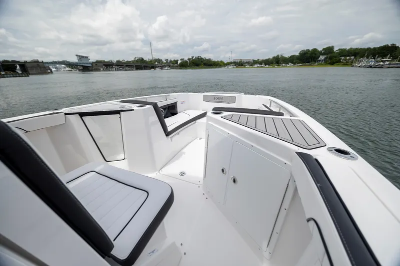 Slide: The Image of 2024 Yamaha Boats 255 FSH Sport H on calm water, showcasing sleek seating and storage. - 15