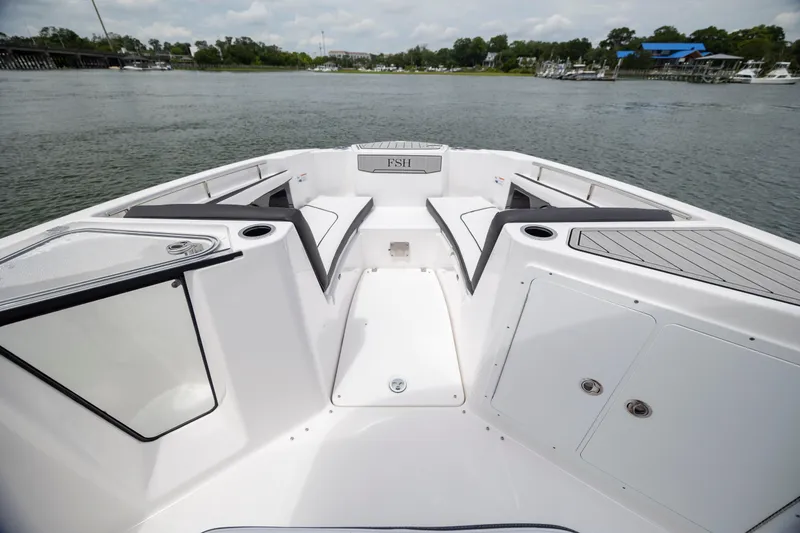 Slide: The Image of 2024 Yamaha Boats 255 FSH Sport H, spacious deck, sleek design, on calm water. - 16