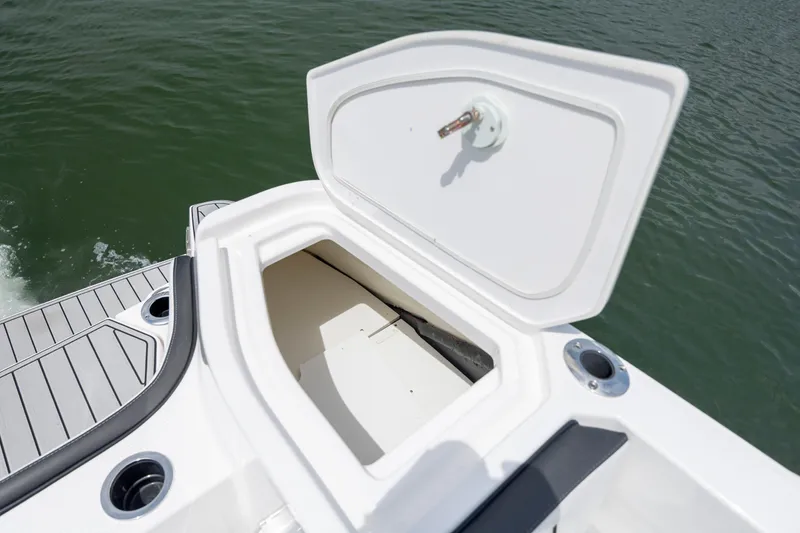 Slide: The Image of Open storage compartment on 2024 Yamaha Boats 255 FSH Sport H, near water. - 19