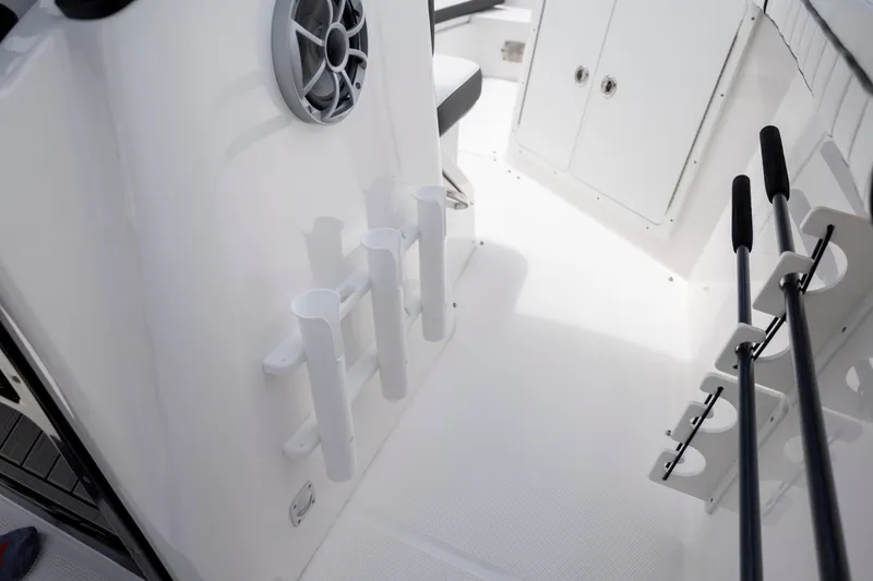 Slide: The Image of 2024 Yamaha Boats 255 FSH Sport H interior with rod holders and storage compartments. - 25