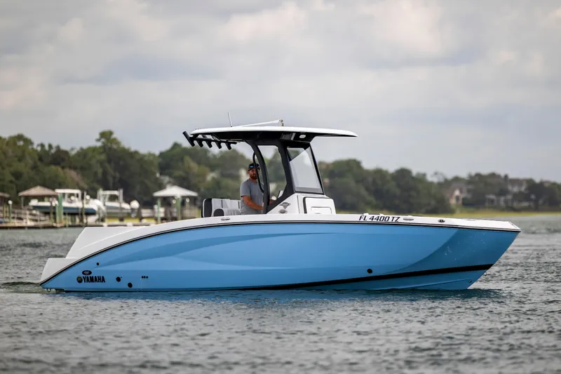 Slide: The Image of 2024 Yamaha Boats 255 FSH Sport H on water, side view, with driver. - 3