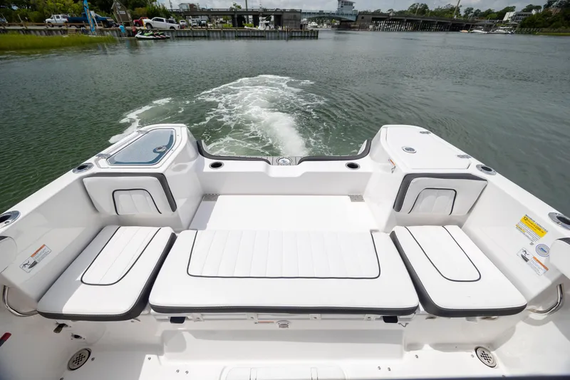 Slide: The Image of 2024 Yamaha Boats 255 FSH Sport H, rear seating view on water. - 7