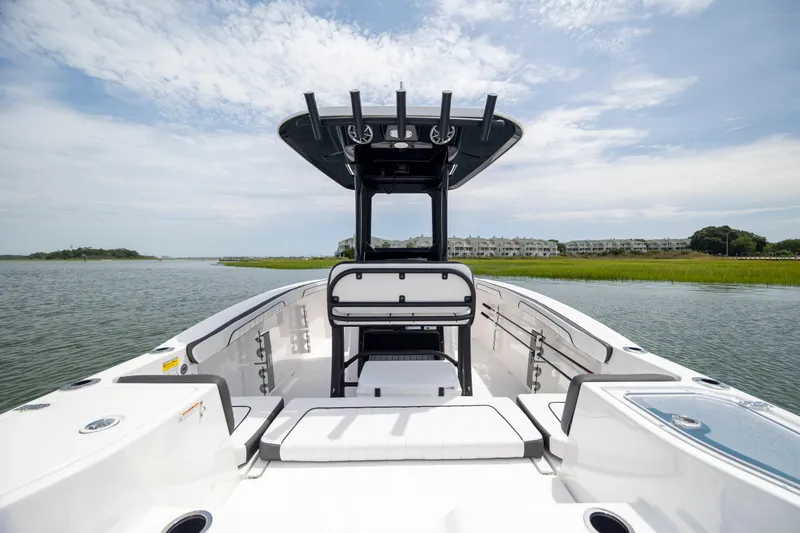 Slide: The Image of 2024 Yamaha Boats 255 FSH Sport H on calm water, showcasing sleek design and spacious deck. - 9