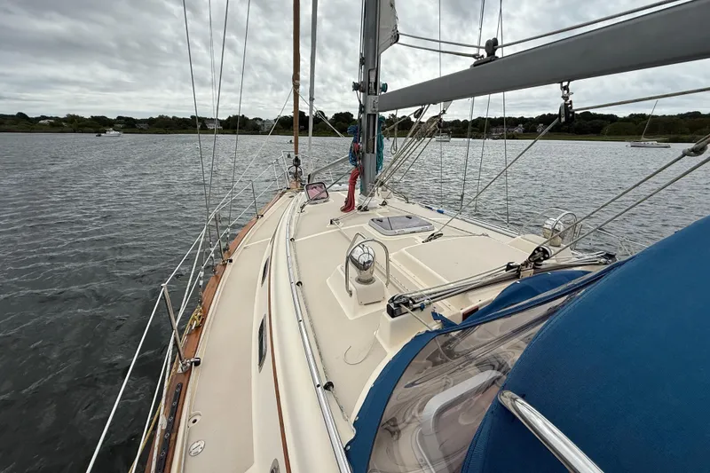 Slide: The Image of 2008 Island Packet 370 sailboat on calm water, showcasing deck and rigging. - 26