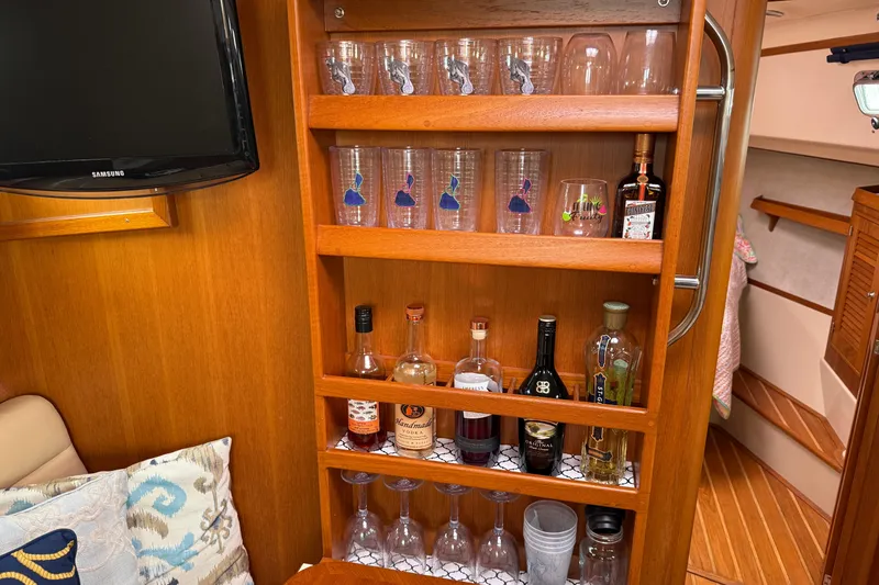 Slide: The Image of Bar area inside 2008 Island Packet 370 yacht with glasses and assorted liquor bottles. - 42
