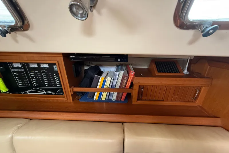 Slide: The Image of Interior of 2008 Island Packet 370 sailboat with books and control panel. - 44