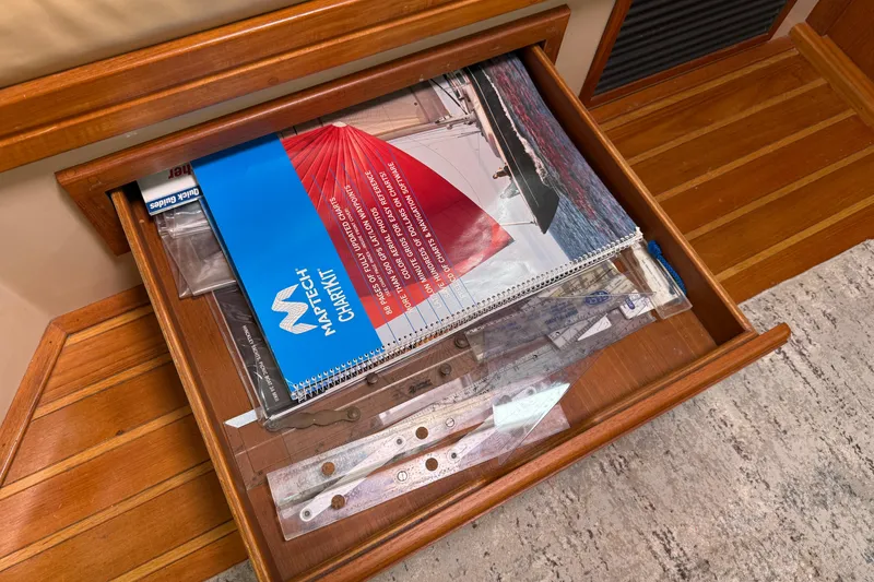 Slide: The Image of Open drawer with nautical charts and navigation tools on Island Packet 370, 2008 model. - 48