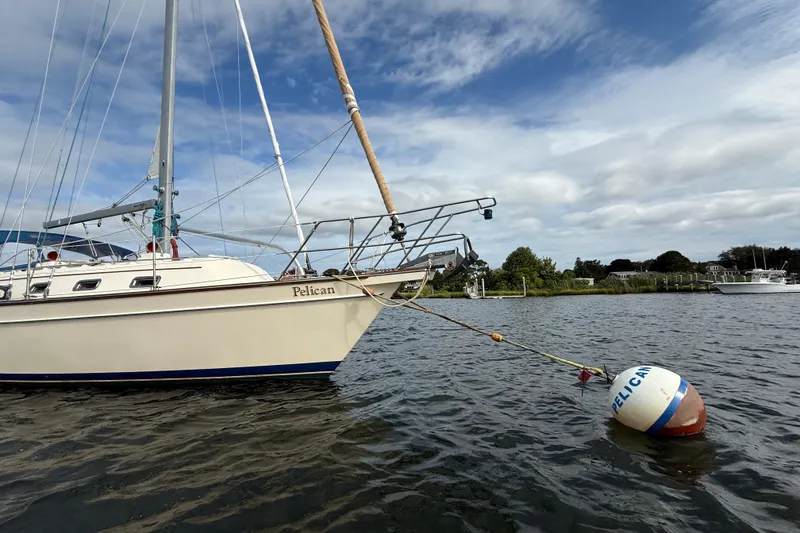 Slide: The Image of 2008 Island Packet 370 sailboat named "Pelican" moored on a calm waterway. - 5