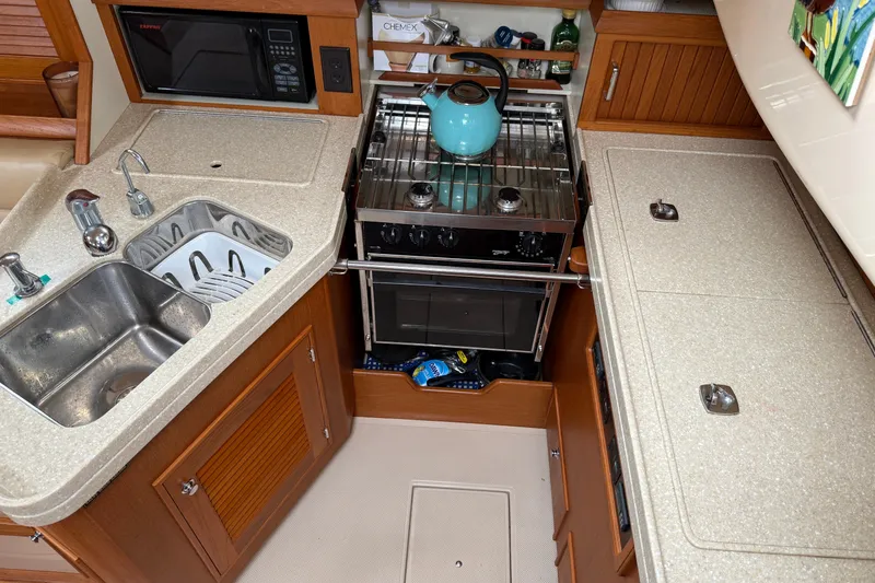 Slide: The Image of 2008 Island Packet 370 yacht kitchen with stove, sink, and microwave. - 50