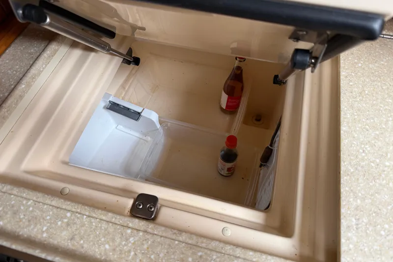 Slide: The Image of Open storage compartment on 2008 Island Packet 370 yacht with bottles inside. - 56