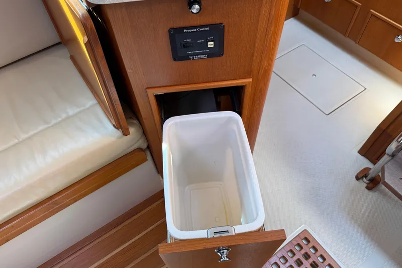 Slide: The Image of Interior of 2008 Island Packet 370 yacht with open cabinet and trash bin. - 59