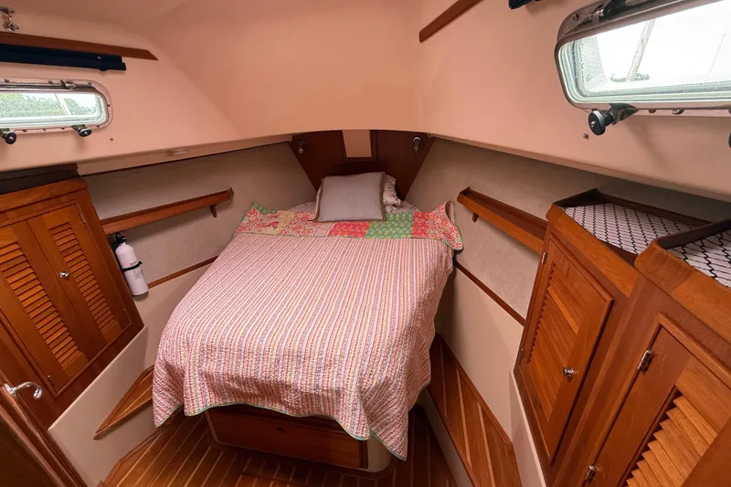 Slide: The Image of Cozy cabin interior of 2008 Island Packet 370 sailboat with bed and wooden storage. - 61