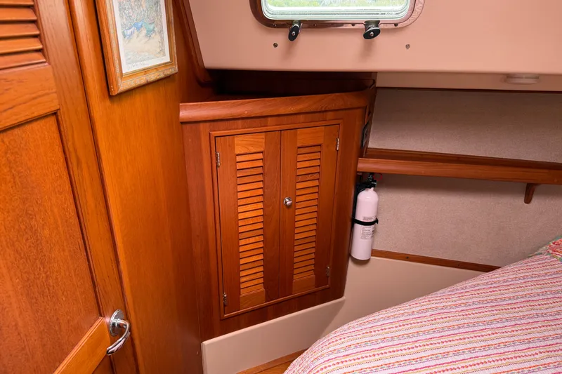Slide: The Image of Interior of 2008 Island Packet 370 sailboat with wooden cabinetry and fire extinguisher. - 64