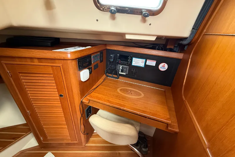 Slide: The Image of 2008 Island Packet 370 navigation station with wooden desk and control panel. - 73