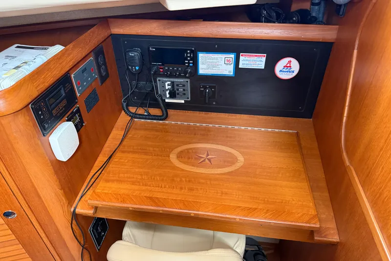 Slide: The Image of Navigation station of 2008 Island Packet 370 sailboat with communication equipment and wooden desk. - 74