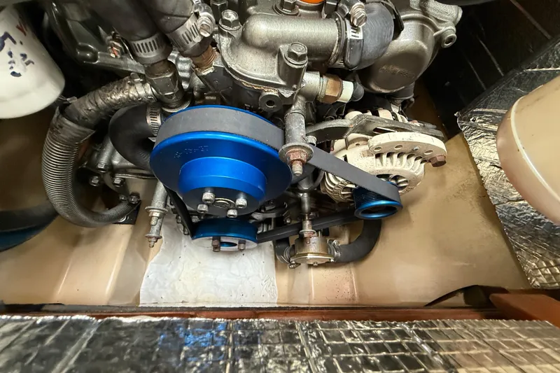 Slide: The Image of Engine compartment of a 2008 Island Packet 370 sailboat, featuring blue pulleys and belts. - 81