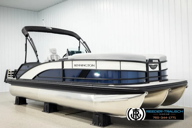 Slide: The Image of 2026 Bennington 22 MSBSE pontoon boat in showroom, featuring sleek design and modern amenities. - 2