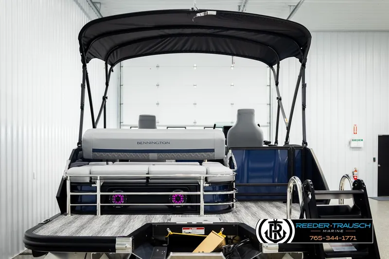 Slide: The Image of 2026 Bennington 22 MSBSE pontoon boat in showroom with canopy and seating. - 7