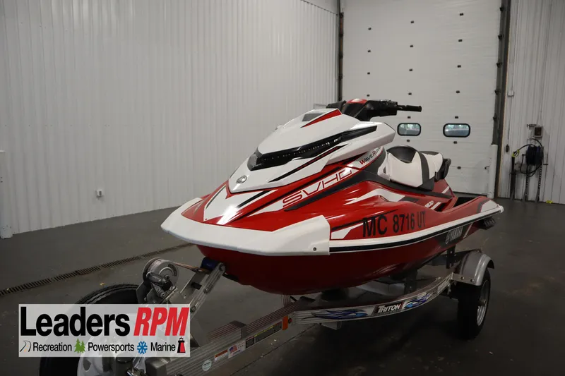 The Image of 2018 Yamaha GP1800 jet ski in red and white on a trailer indoors. - 1
