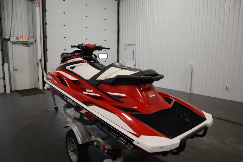 Slide: The Image of 2018 Yamaha GP1800 jet ski in red and white, displayed indoors on a trailer. - 7