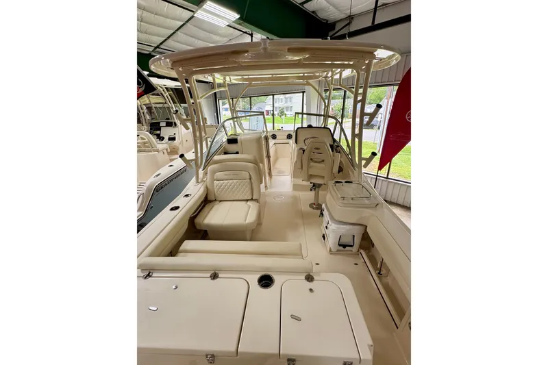Slide: The Image of 2026 Grady-White Freedom 235 boat interior, showcasing seating and helm in a showroom. - 3
