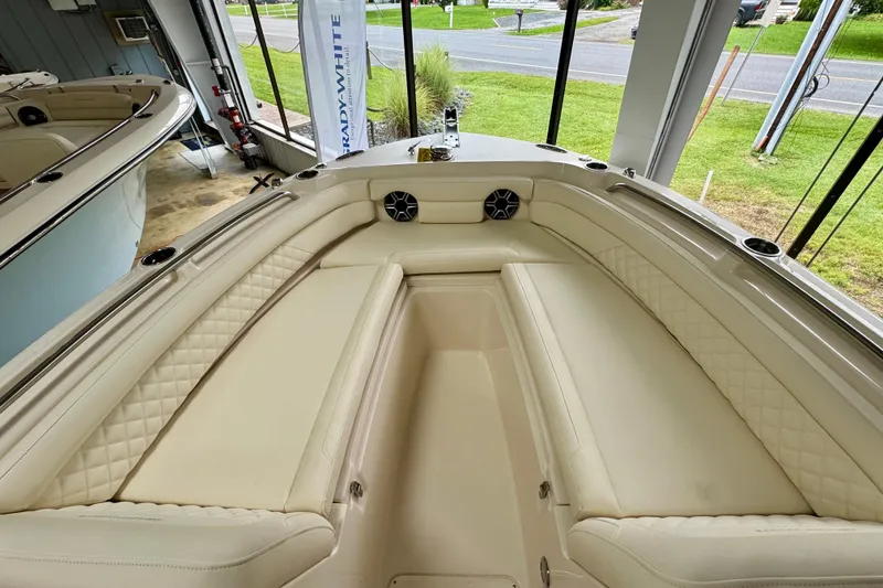 Slide: The Image of 2026 Grady-White Freedom 235 boat interior with beige seating and cup holders. - 9