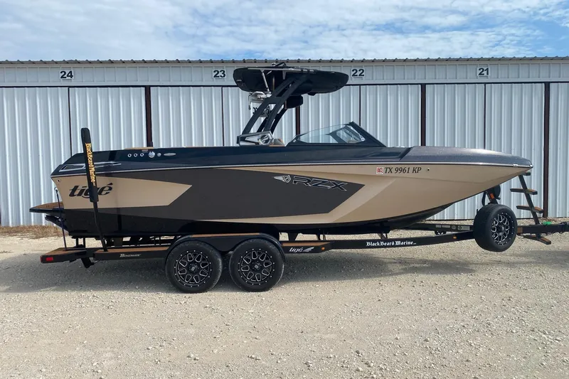 The Image of 2021 Tigé 23RZX boat on trailer, parked in front of storage units. - 0