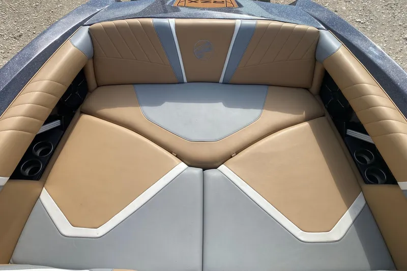 Slide: The Image of 2021 Tigé 23RZX boat interior with tan and gray cushioned seating. - 8