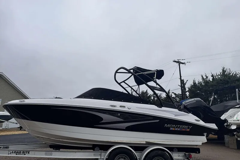 Slide: The Image of 2024 Monterey M205 boat on trailer, black and white design, overcast sky. - 4