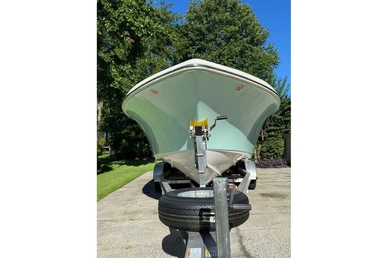 Slide: The Image of 2021 Key West 239 DFS boat on trailer, parked outdoors with trees in background. - 3