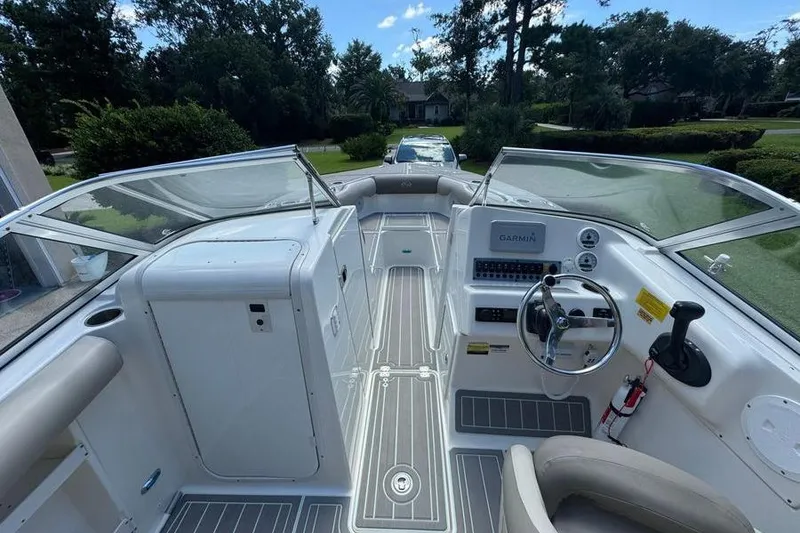 Slide: The Image of 2021 Key West 239 DFS boat interior with steering wheel and dashboard, parked outdoors. - 7