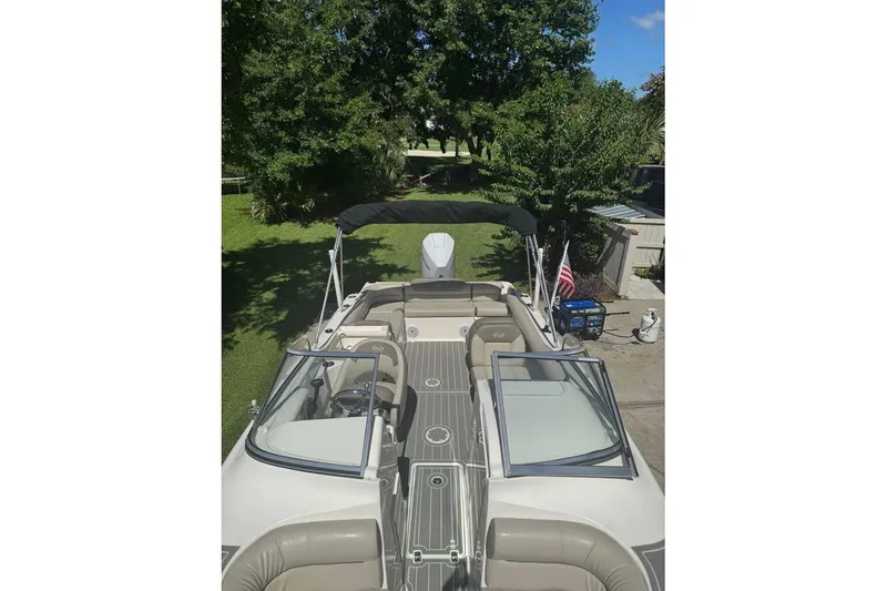 Slide: The Image of 2021 Key West 239 DFS boat with seating, windshield, and American flag in a garden setting. - 9
