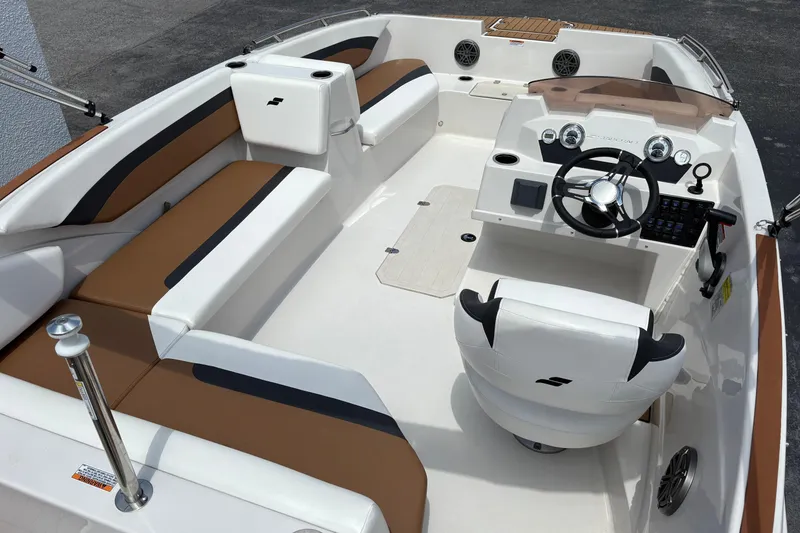 Slide: The Image of 2021 Starcraft SVX 171 OB boat interior with brown and white seating, modern dashboard, and steering wheel. - 4