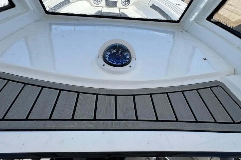Slide: The Image of 2025 Tidewater 282 CC Adventure boat dashboard with compass and non-slip surface. - 15
