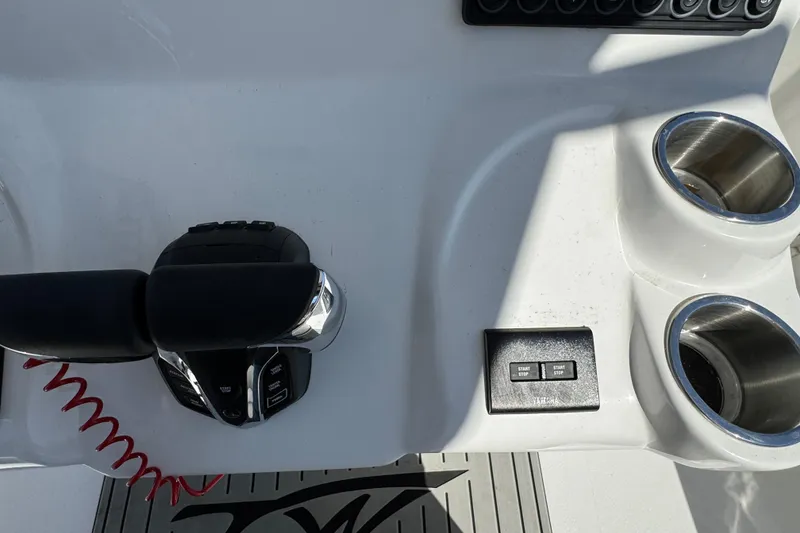 Slide: The Image of 2025 Tidewater 282 CC Adventure boat controls with dual cup holders and start-stop buttons. - 18