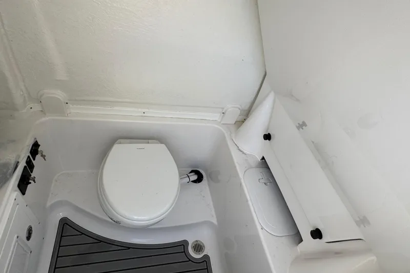 Slide: The Image of 2025 Tidewater 282 CC Adventure boat interior with a compact marine toilet. - 23