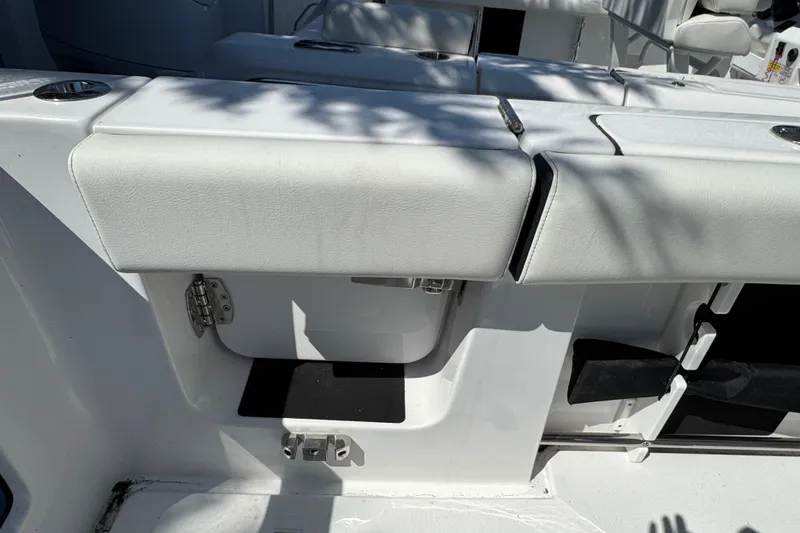 Slide: The Image of 2025 Tidewater 282 CC Adventure boat seating area with cup holders and storage. - 9