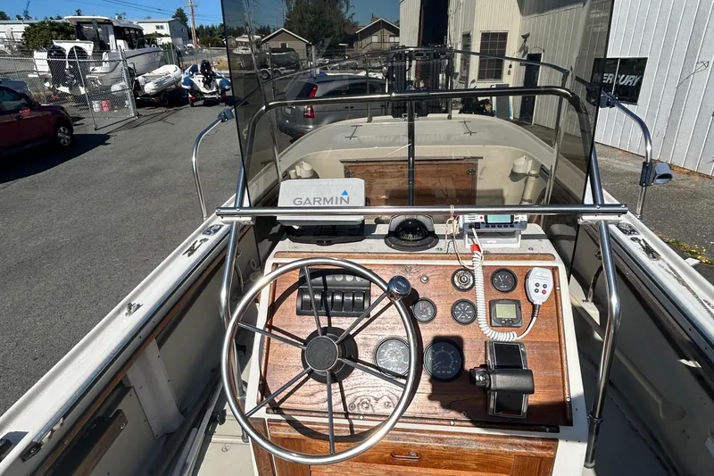 Slide: The Image of 1977 Boston Whaler 19 Outrage boat dashboard with steering wheel and navigation instruments. - 1