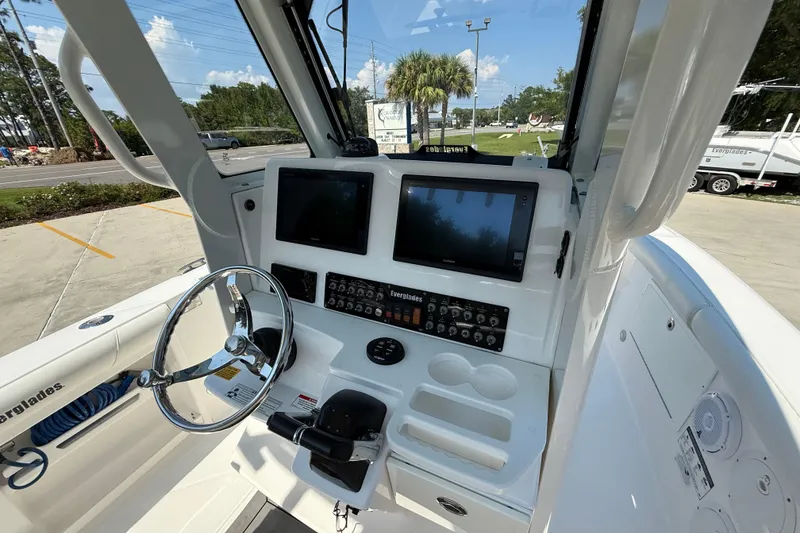 Slide: The Image of 2016 Everglades 255 Center Console boat dashboard with dual screens and steering wheel. - 9