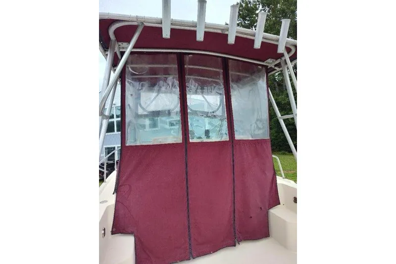 Slide: The Image of 1996 Parker 2110 Walkaround boat with maroon canvas enclosure and rod holders. - 10