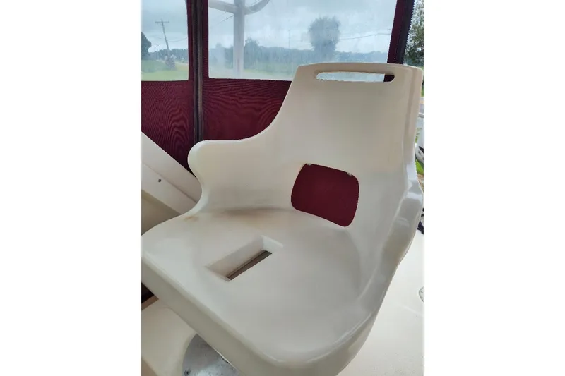 Slide: The Image of White seat on a 1996 Parker 2110 Walkaround boat, with maroon backdrop. - 17