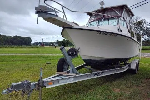 Slide: The Image of 1996 Parker 2110 Walkaround boat on trailer, parked on grassy area. - 2