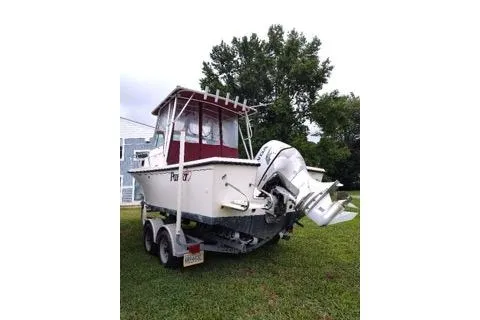 Slide: The Image of 1996 Parker 2110 Walkaround boat on trailer, parked on grass. - 4