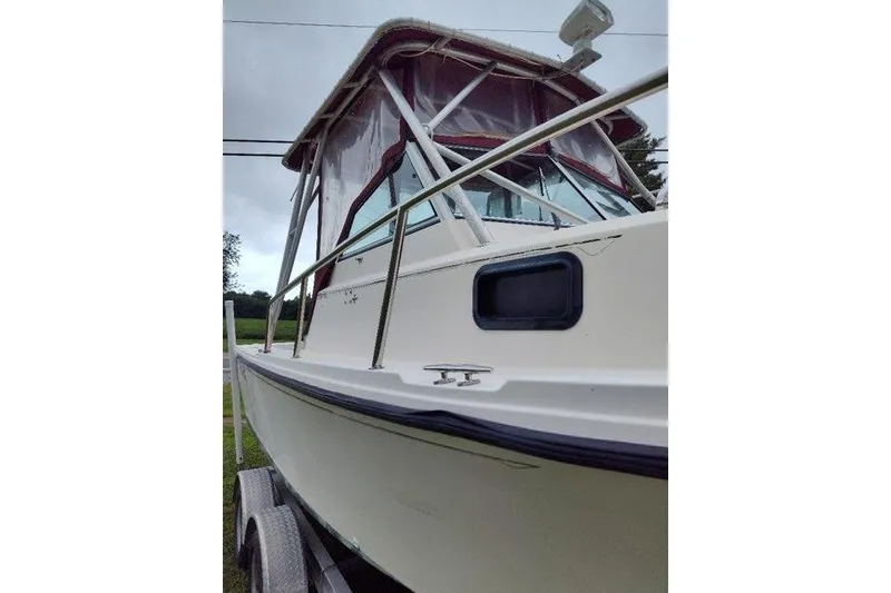 Slide: The Image of 1996 Parker 2110 Walkaround boat with canopy, viewed from the side on a trailer. - 8