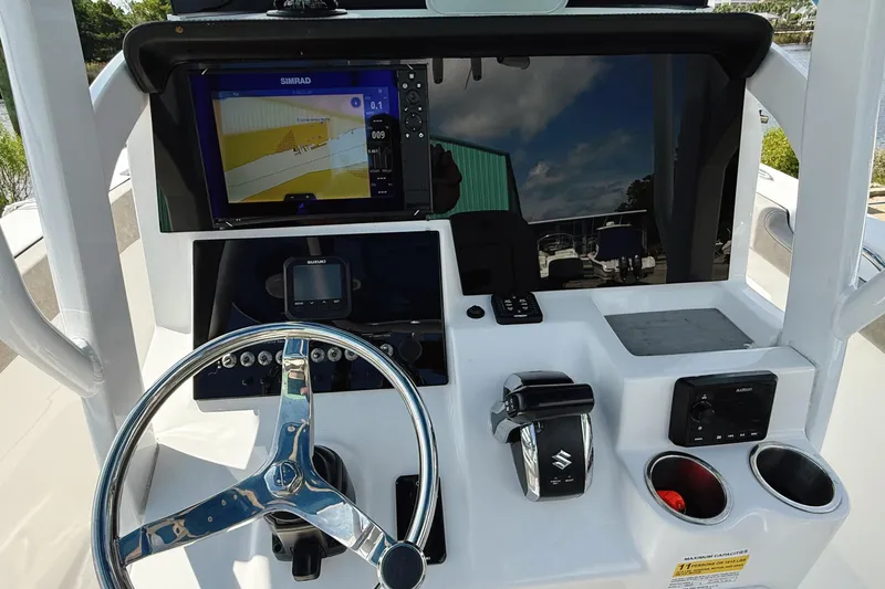 Slide: The Image of 2023 Sea Pro 239 DLX boat dashboard with steering wheel and navigation system. - 16